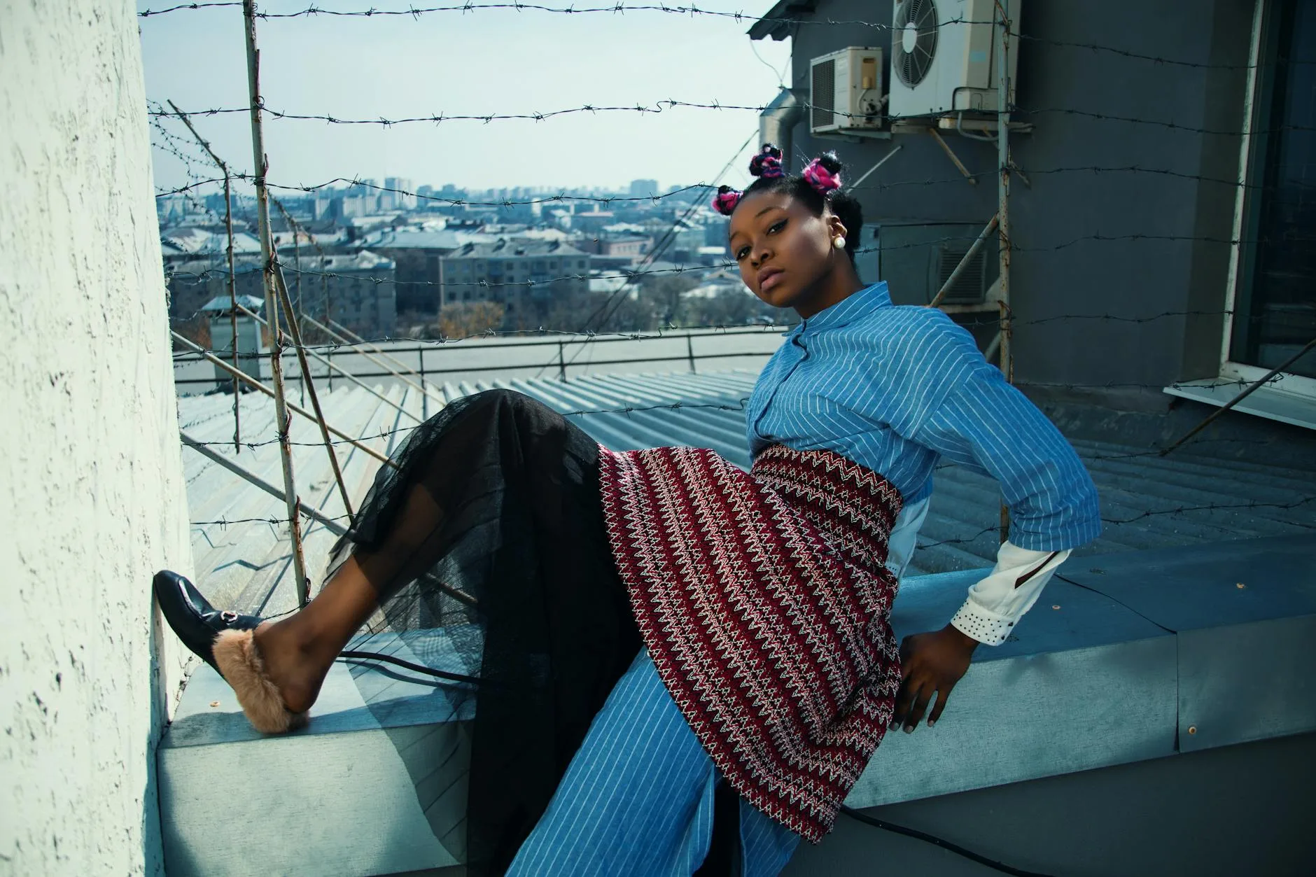 Elegancka kobieta pozuje na dachu wieżowca z panoramą Warszawy