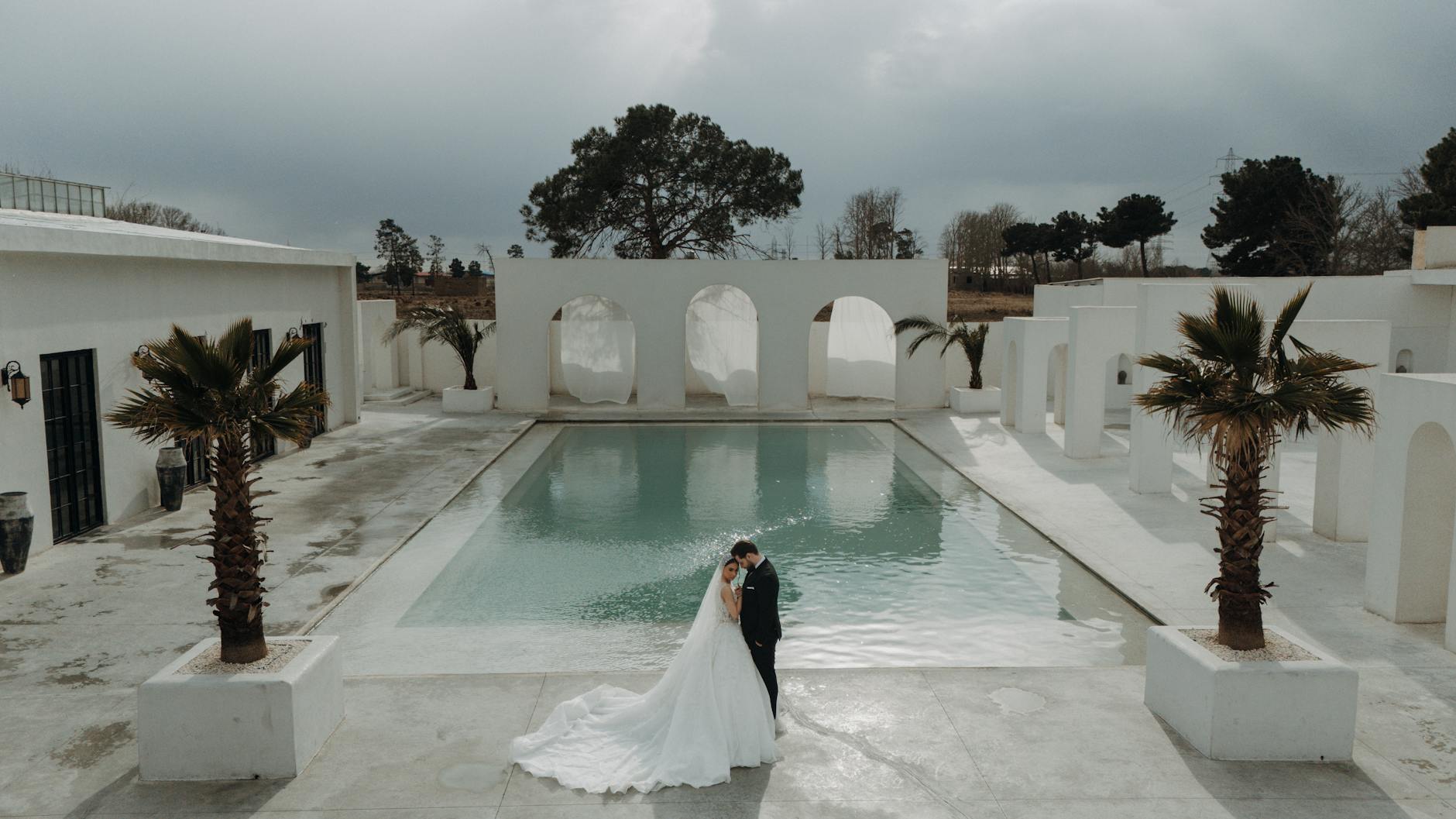 Para młoda nad basenem podczas letniej plenerowej sesji ślubnej
