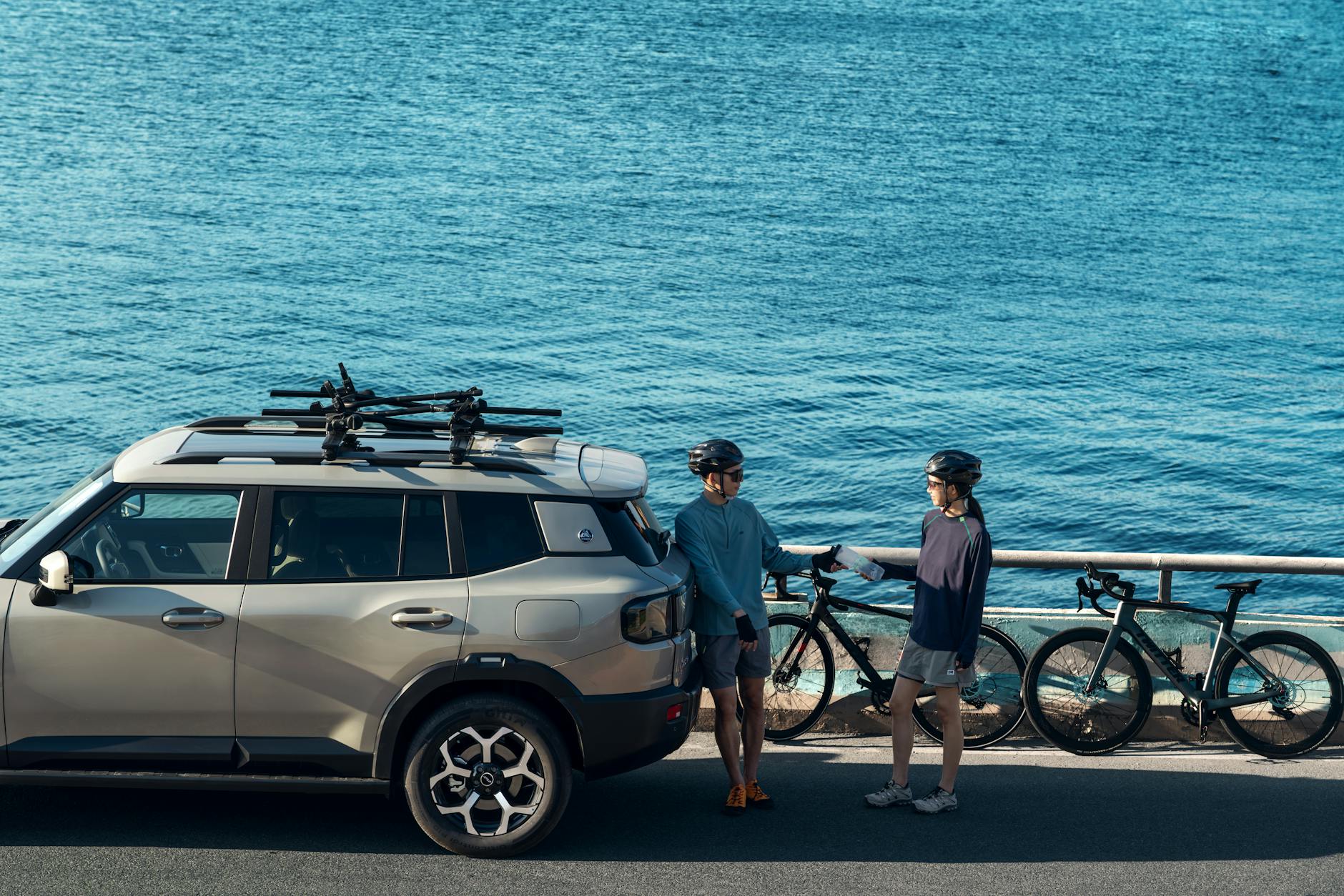 Rodzina z rowerami przy zapakowanym SUV-ie nad morzem
