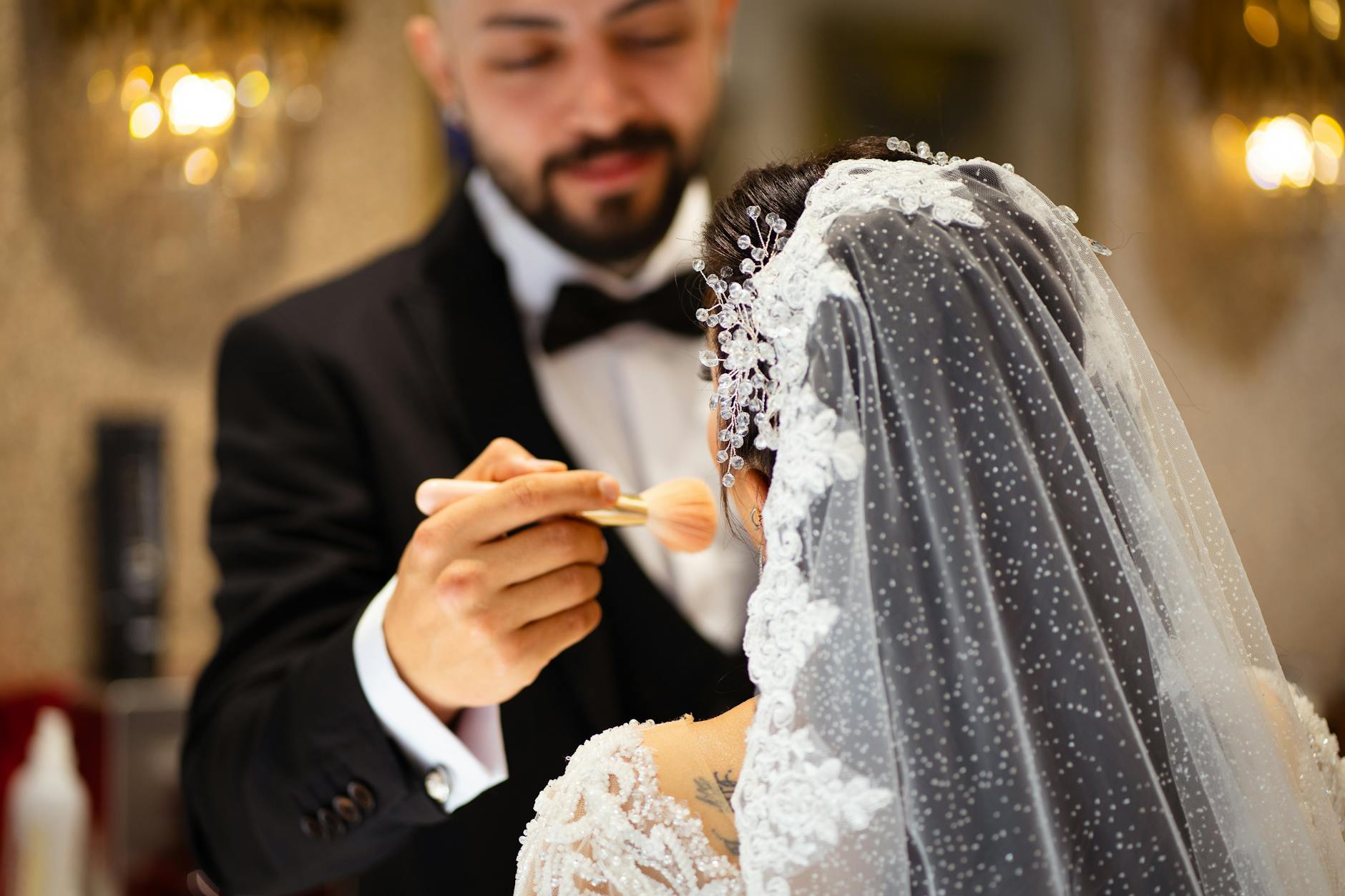 Pan młody poprawia makijaż panny młodej przed ceremonią ślubną
