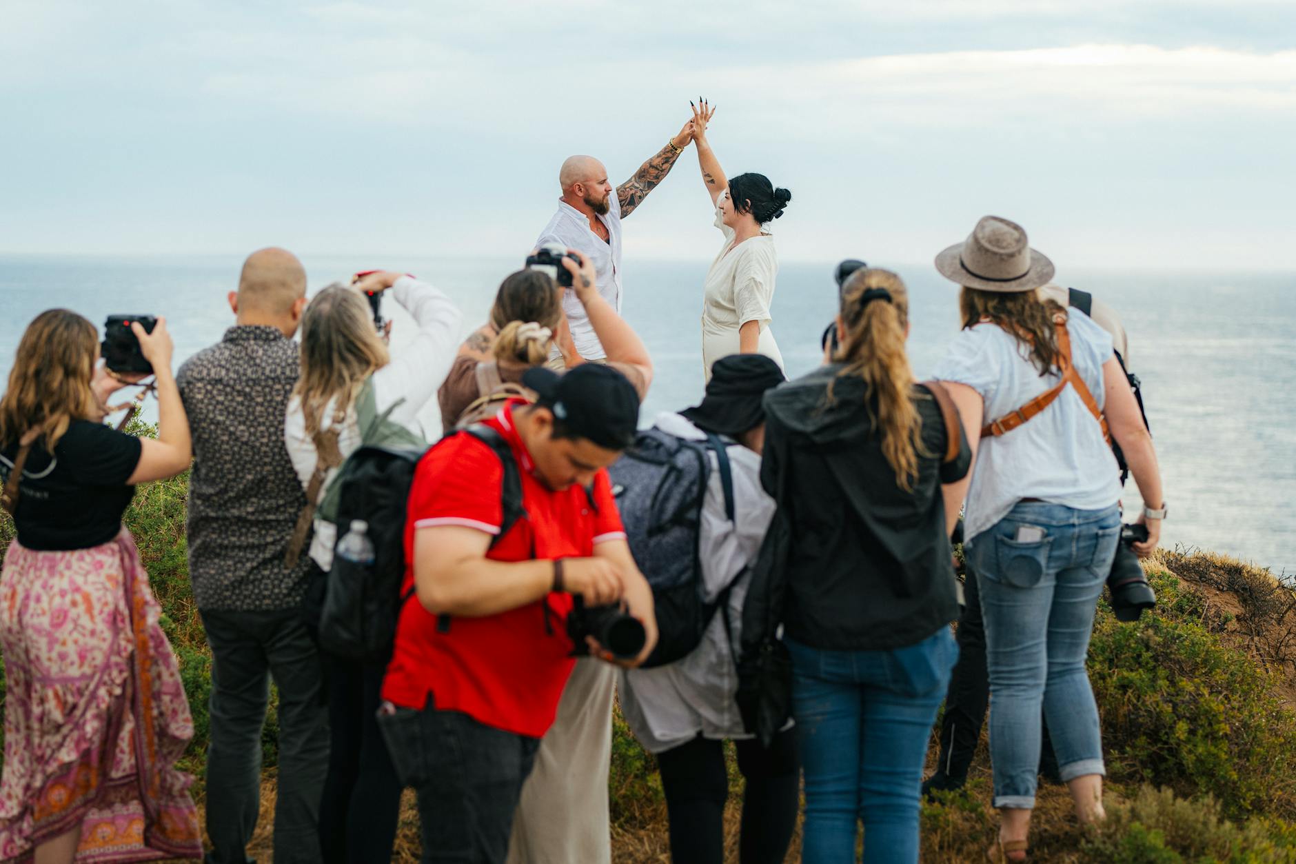 Od pierwszego maila po ostatnie zdjęcie: jak wygląda współpraca z fotografem ślubnym w Warszawie krok po kroku Para młoda pozująca nad morzem otoczona fotografami podczas sesji ślubnej