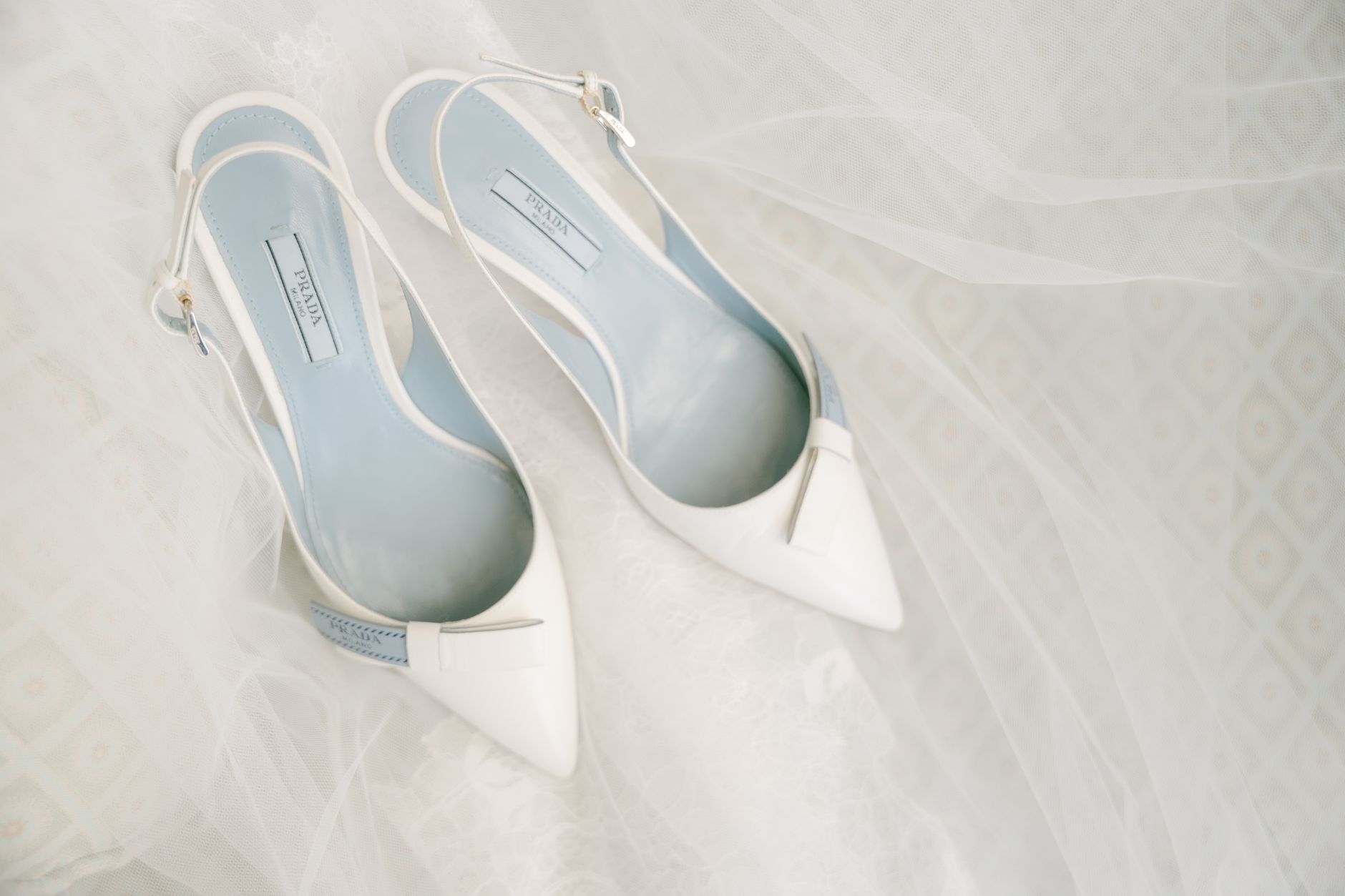 Białe eleganckie buty ślubne na delikatnym welonie