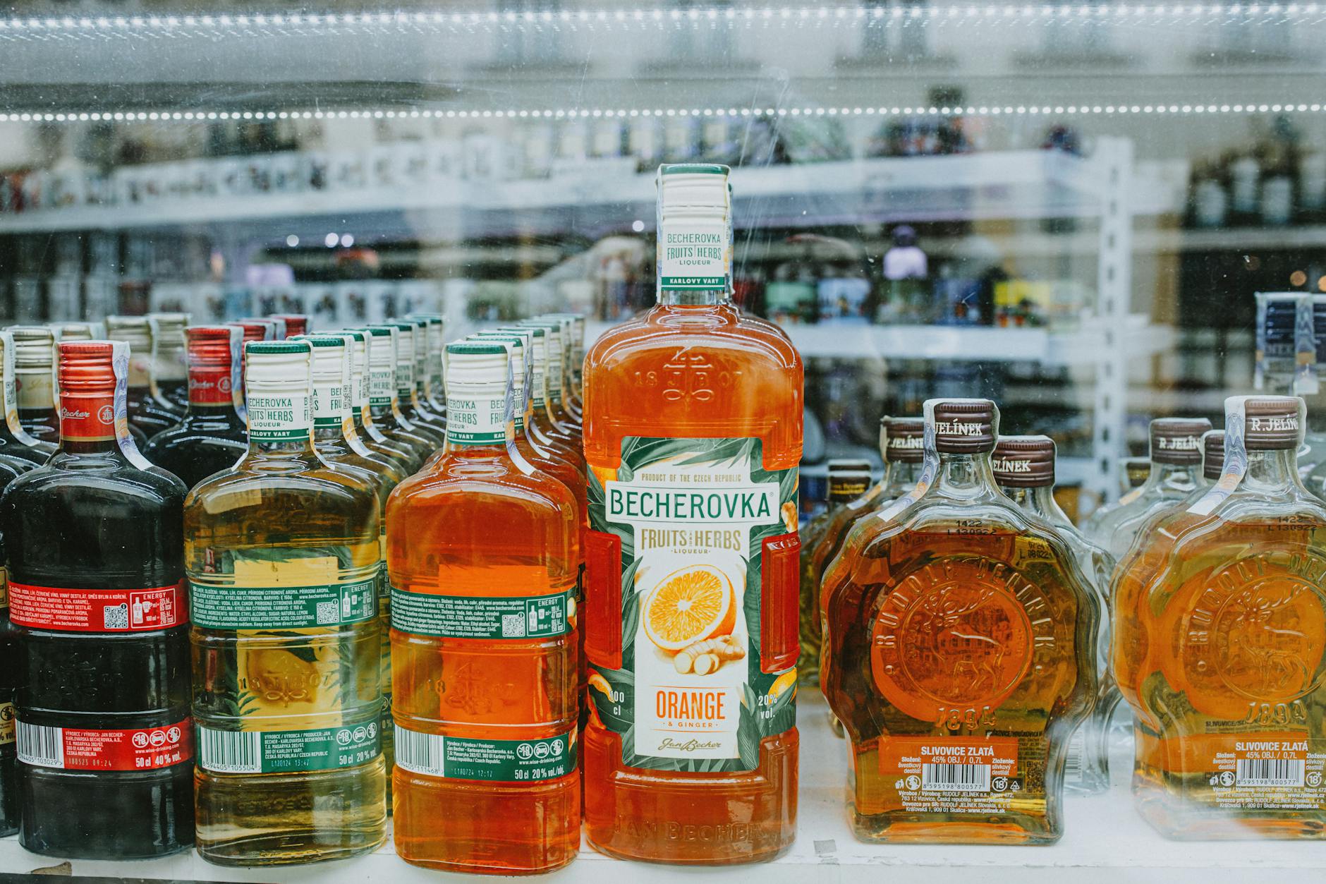 Kolorowe butelki alkoholu ustawione na półce sklepowej