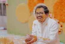 Roześmiany pan młody podczas ceremonii Haldi, pokryty kurkumą
